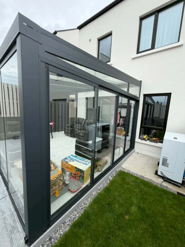 Pergola veranda closed in with frameless sliding glass doors