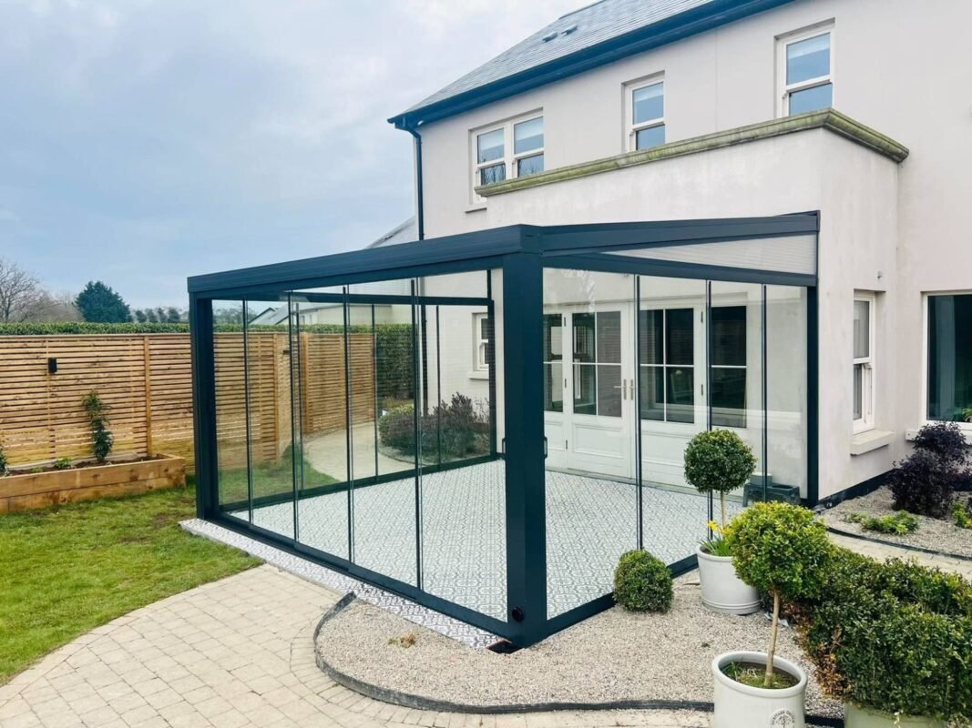 Veranda closed in with frameless sliding glass panels